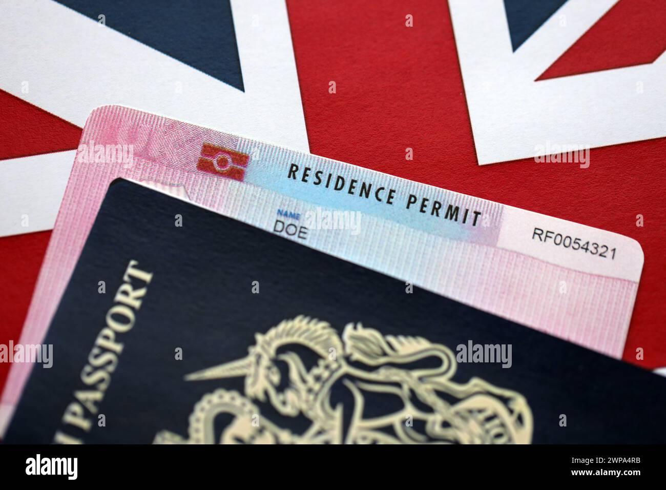 Permesso di soggiorno carta BRP e passaporto britannico del Regno Unito con la bandiera Union Jack primo piano Foto Stock