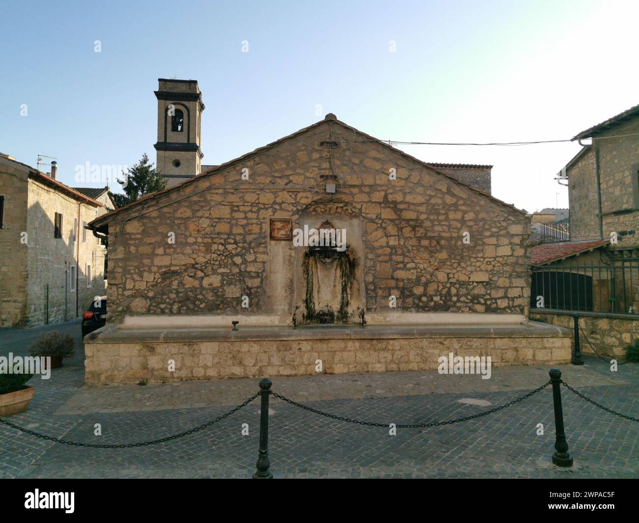 Una chiesa di pietra vicino al recinto di ferro nero Foto Stock