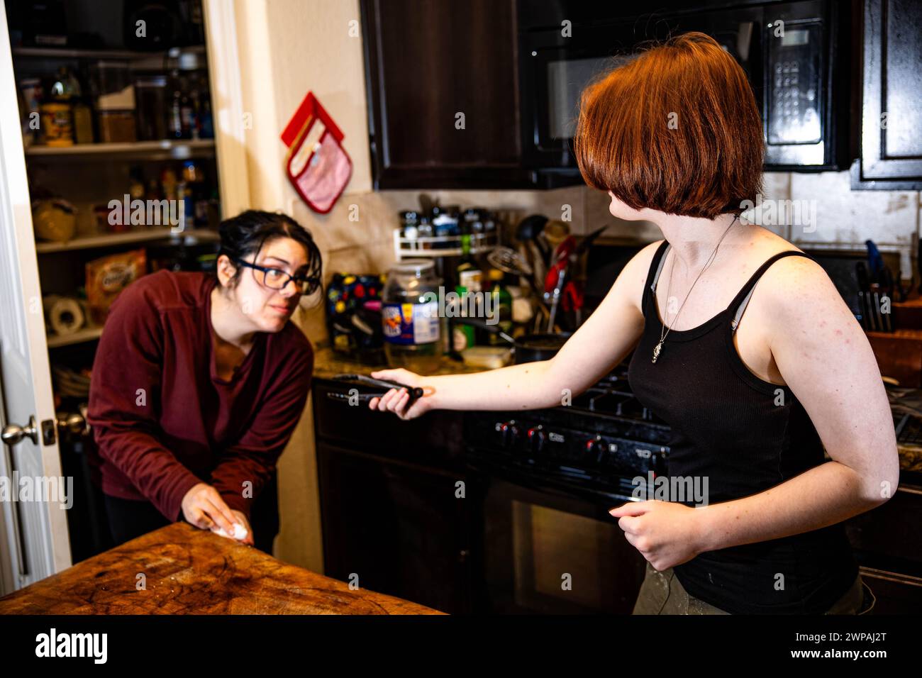 Una donna che tiene un coltello, che ha un contatto visivo con un'altra donna Foto Stock