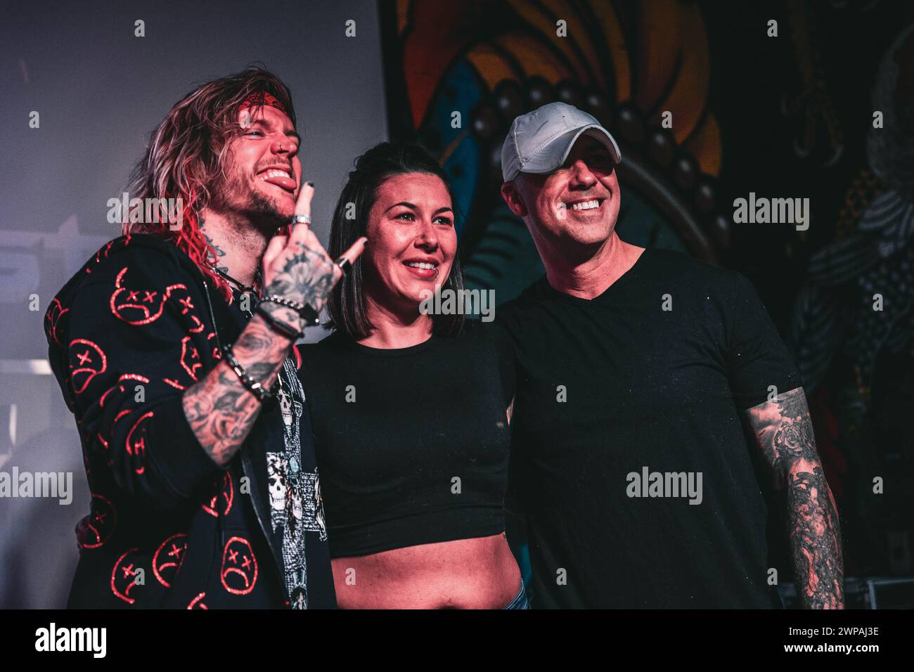 Un gruppo eterogeneo di individui che si schierano in unità, alzando un segno di pace Foto Stock