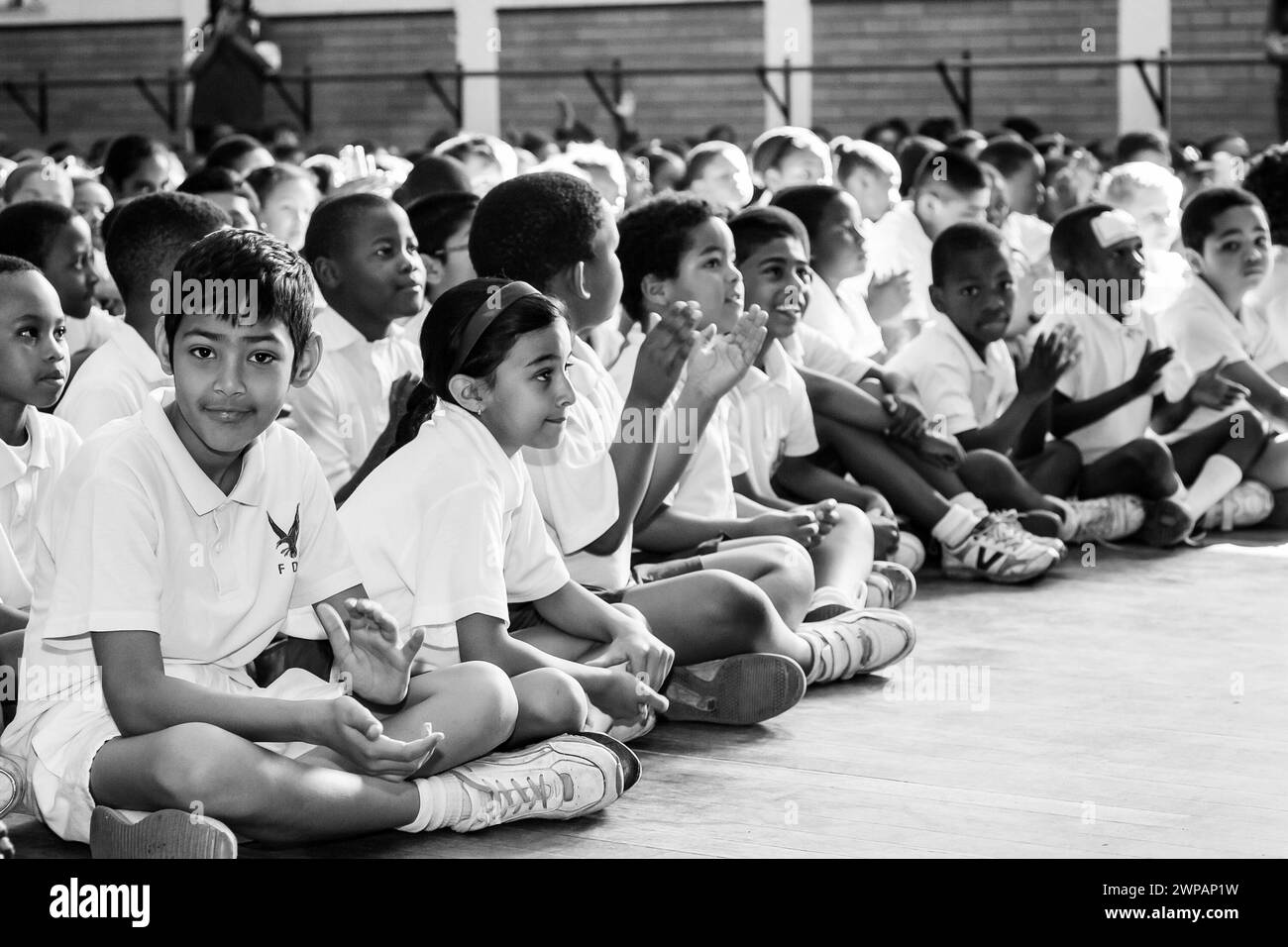 Immagine monocromatica di bambini e adulti seduti sul pavimento Foto Stock