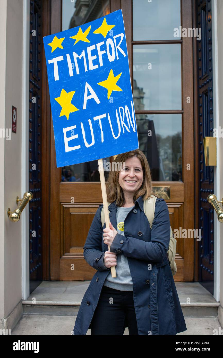 Manifestante donna che tiene in mano un cartello con l'ora del messaggio per un turno dell'ue . Foto Stock