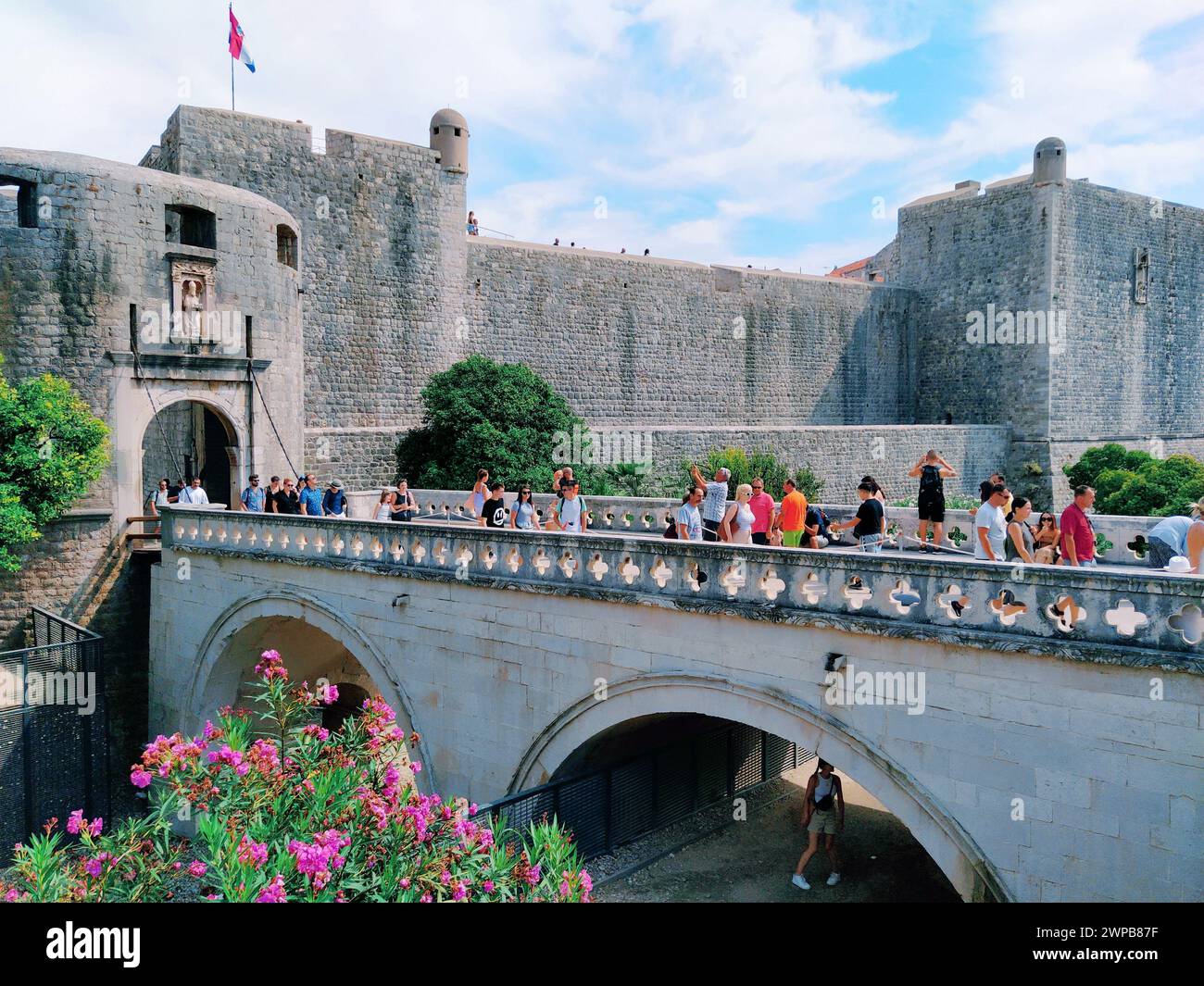 Pile Gate Dubrovnik Croazia 14 agosto 2022 persone uomini e donne camminano lungo il ponte di pietra fino al cancello della città Vecchia. Una folla di turisti. Occupato Foto Stock