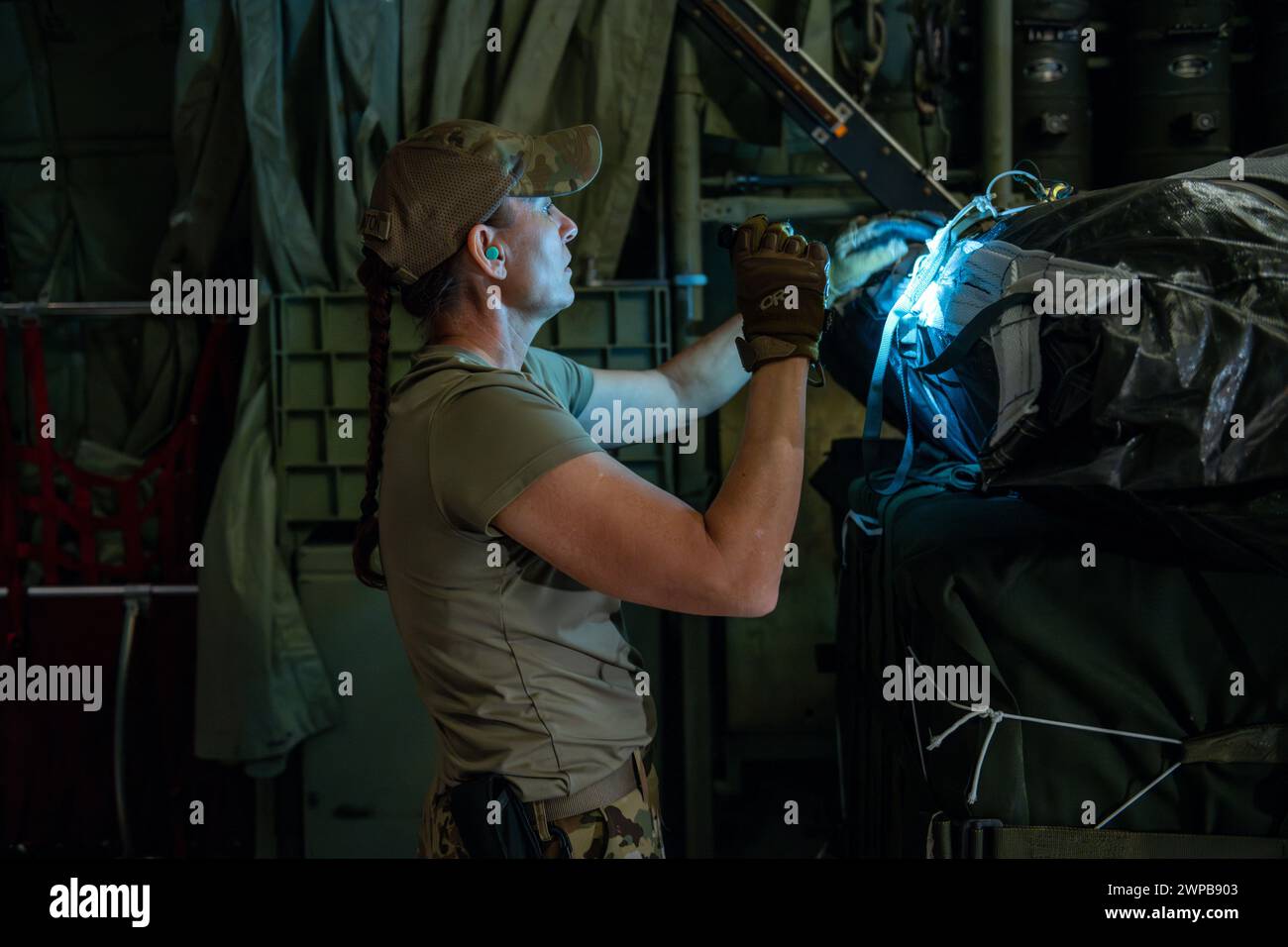 Azraq, Giordania. 5 marzo 2024. Un comandante della US Air Force controlla l'equipaggiamento di armamento su un paracadute attaccato a pallet di aiuti umanitari nella stiva di carico di un aereo C-130J Super Hercules della US Air Force presso la Muwaffaq salti Air base, 5 marzo 2024 ad Azraq, Governatorato di Zarqa, Giordania. Gli aiuti alimentari saranno lanciati in aria ai rifugiati palestinesi intrappolati dalla guerra israeliana contro Hamas. Crediti: SRA Lauren Jacoby/US Airforce Photo/Alamy Live News Foto Stock