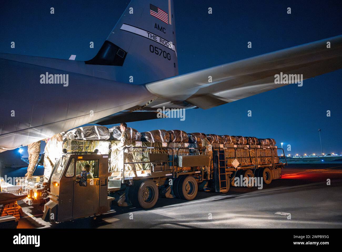Azraq, Giordania. 5 marzo 2024. I soldati dell'esercito statunitense e gli aviatori dell'aeronautica militare caricano pallet di aiuti umanitari nella stiva di carico di un aereo C-130J Super Hercules dell'aeronautica statunitense presso la Muwaffaq salti Air base, 5 marzo 2024, ad Azraq, Governatorato di Zarqa, Giordania. Gli aiuti alimentari saranno lanciati in aria ai rifugiati palestinesi intrappolati dalla guerra israeliana contro Hamas. Crediti: SRA Lauren Jacoby/US Airforce Photo/Alamy Live News Foto Stock