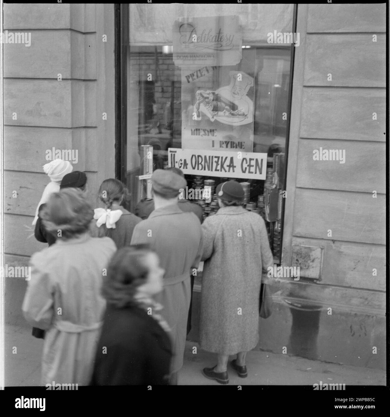 Persone a Varsavia di fronte a un negozio che mostra riduzioni di prezzo annunciate dal governo per il 1° maggio 1954, fotografate per una serie di fotogiornalismo. Foto Stock