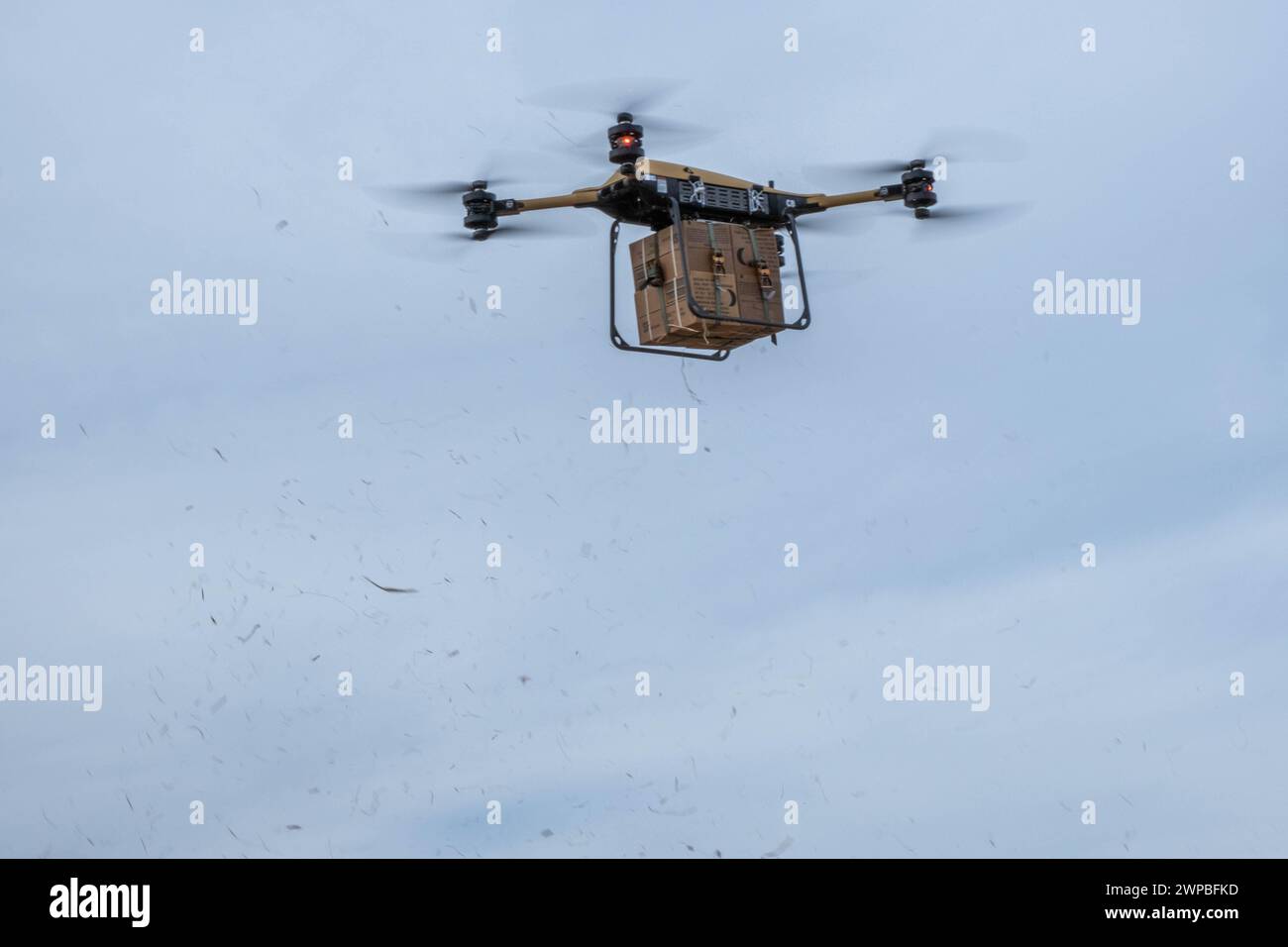 Un TRV 150, veicolo di rifornimento tattico, con un pacchetto di pasti, pronto per mangiare vola sopra un'area di addestramento a Fort Drum, New York, 5 marzo 2024. Soldati con 10th Mountain Division, assistiti dal Civil Military Innovation Institute, conducono TRV 150, Tactical Resupply Vehicle, addestramento a Fort Drum, New York, 5 marzo 2024. Questa operazione si è svolta al fine di innovare il modo in cui le missioni di rifornimento sono condotte con un'altra disponibilità su come la missione può essere eseguita. Essere in grado di rifornire i soldati con equipaggiamento di supporto senza avere alcun soldato a rischio di pericolo è un viale la 10th Mountain Divis Foto Stock