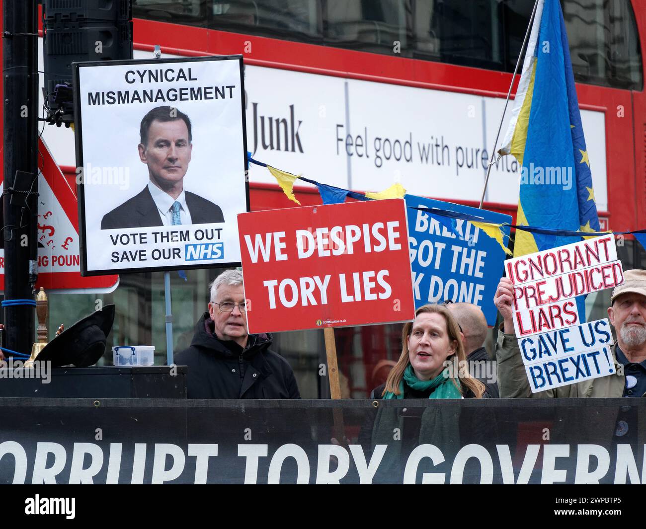 Manifestanti che sventolano striscioni e cartelli con slogan anti-Tory e anti-Brexit fuori dal Parlamento di Westminster a Londra il giorno del bilancio 6 marzo 2024 Foto Stock