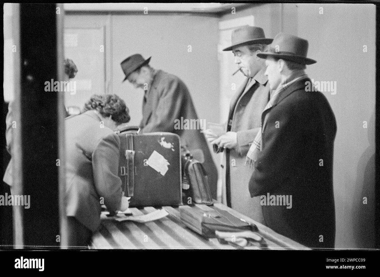 Fotografia che mostra il passaporto e lo sdoganamento alla stazione estera dell'aeroporto di Varsavia, 1959, con i doganieri e i viaggiatori durante l'ispezione dei bagagli. Foto Stock