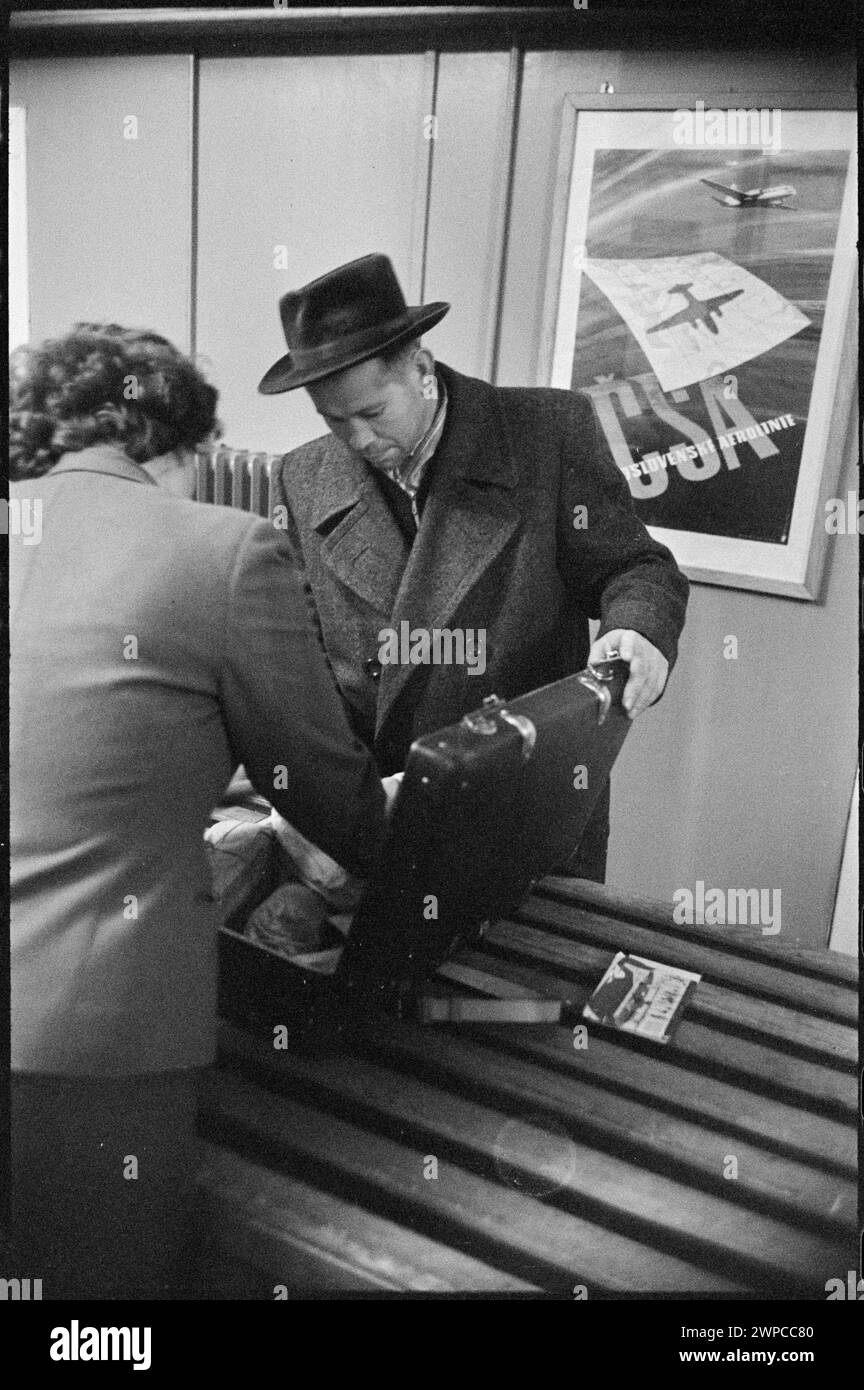 Fotografia che raffigura la dogana e i viaggiatori durante l'ispezione del passaporto e dei bagagli alla stazione estera dell'aeroporto di Varsavia nel 1959. Foto Stock