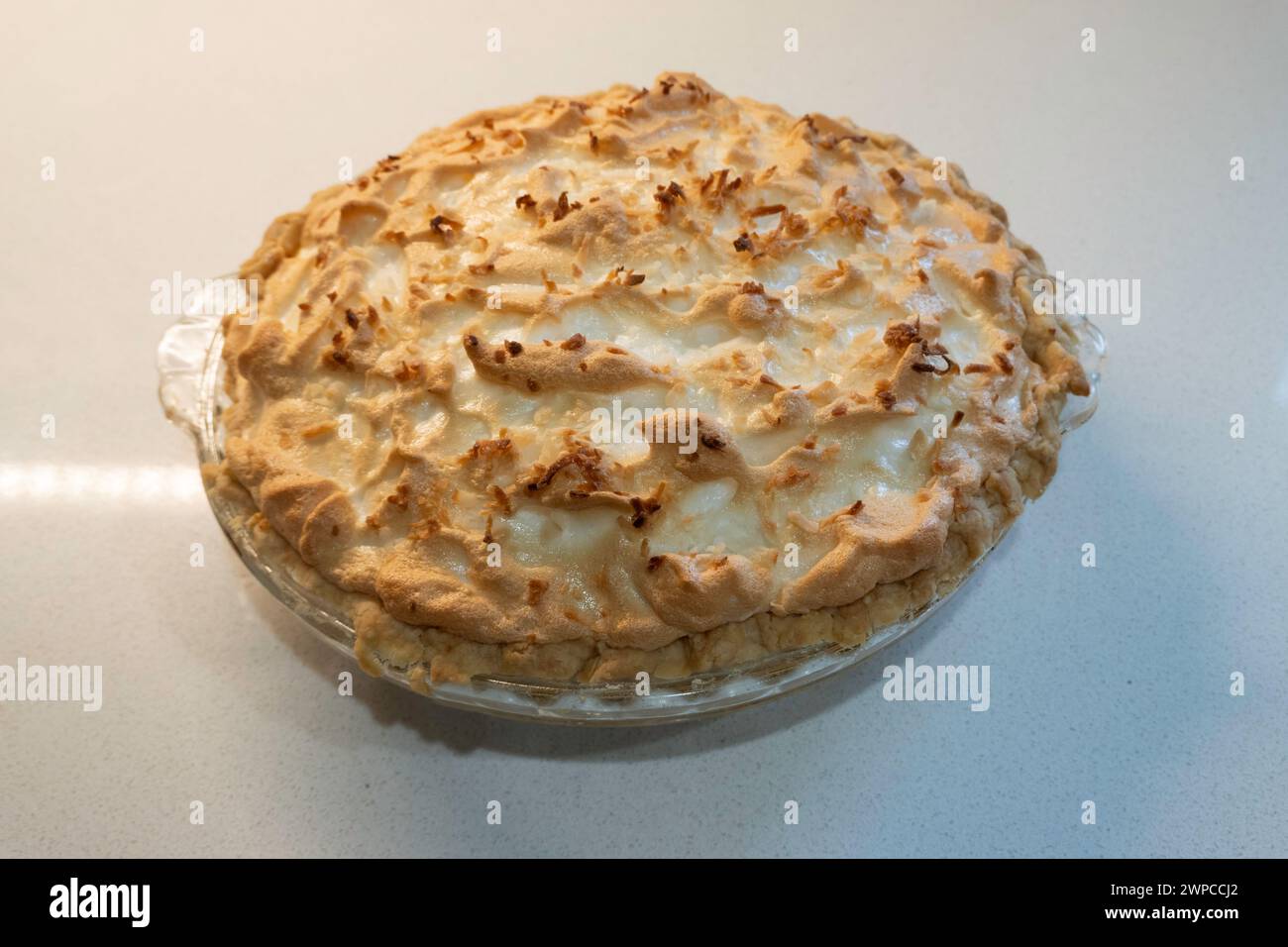 Meringa di crema di cocco appena sfornata, torta intera isolata su sfondo bianco. STATI UNITI Foto Stock