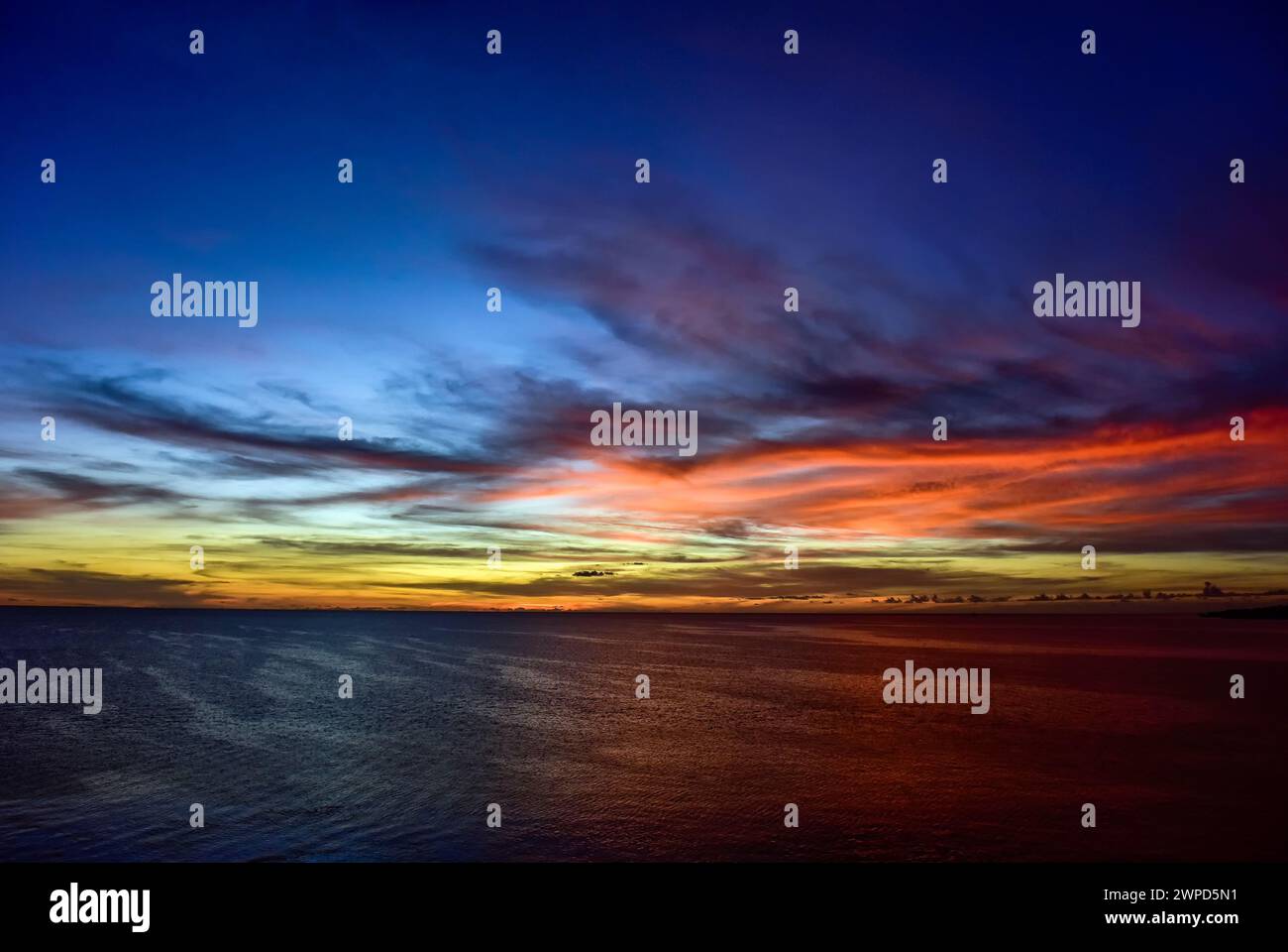 Spettacolare cielo caraibico con giallo, blu, arancione e rosso Foto Stock