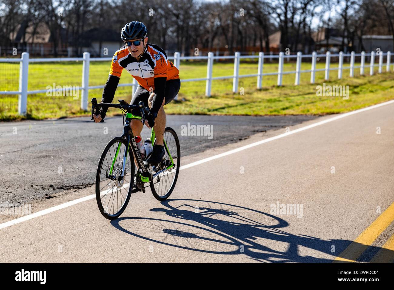 Un uomo che pedala per una strada cittadina in bicicletta ad Arlington, Stati Uniti Foto Stock