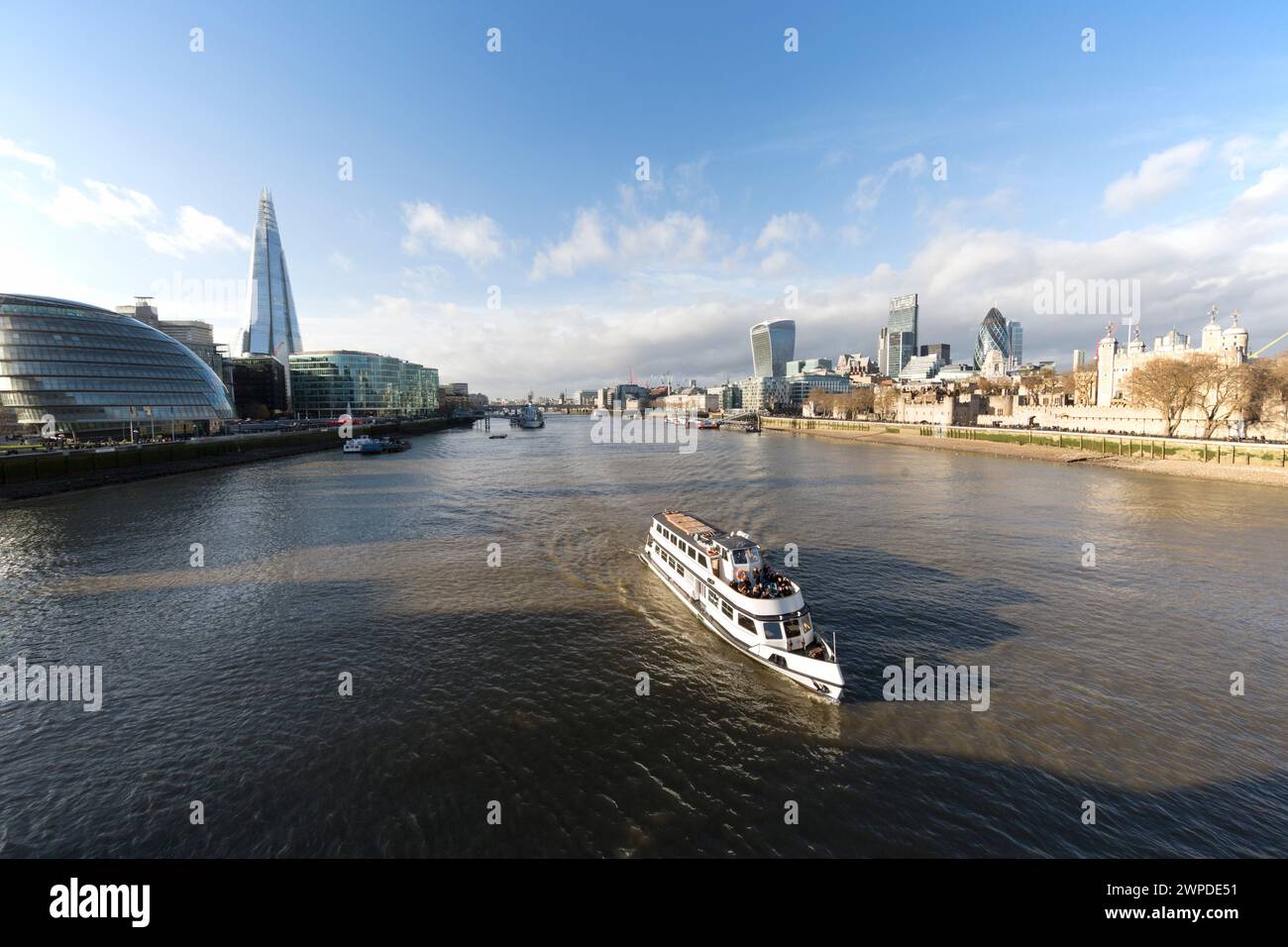 Regno Unito, Londra, barca turistica che naviga sul Tamigi con l'iconico skyline della città. Foto Stock