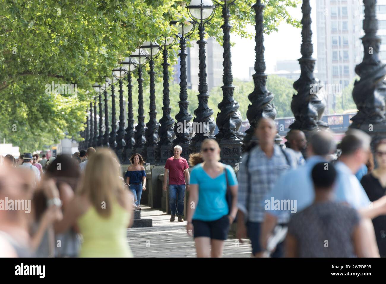 Regno Unito, Londra, Southbank Path con lampioni e turisti vicino al Westminster Bridge. Foto Stock