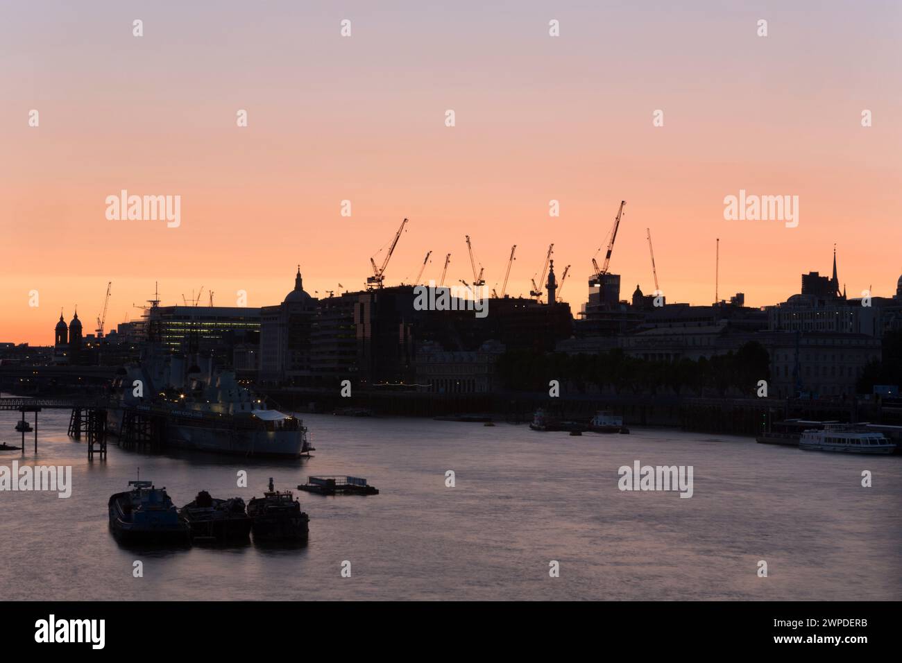 Regno Unito, Londra, il Tamigi e la città (nord) che mostrano enormi sviluppi con gru a braccio in sillouette. Foto Stock