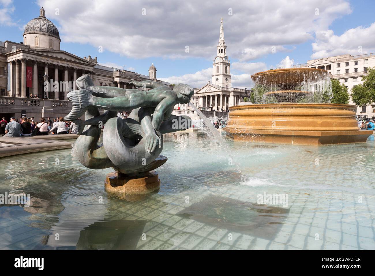 UK, Londra, Bronzo Dolphin e fontana mermen scultura da William McMillan, Trafalger square, 1948. Foto Stock