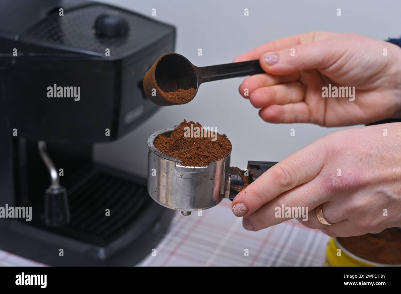 le mani delle donne versano un caffè profumato nella macchina da caffè Foto Stock