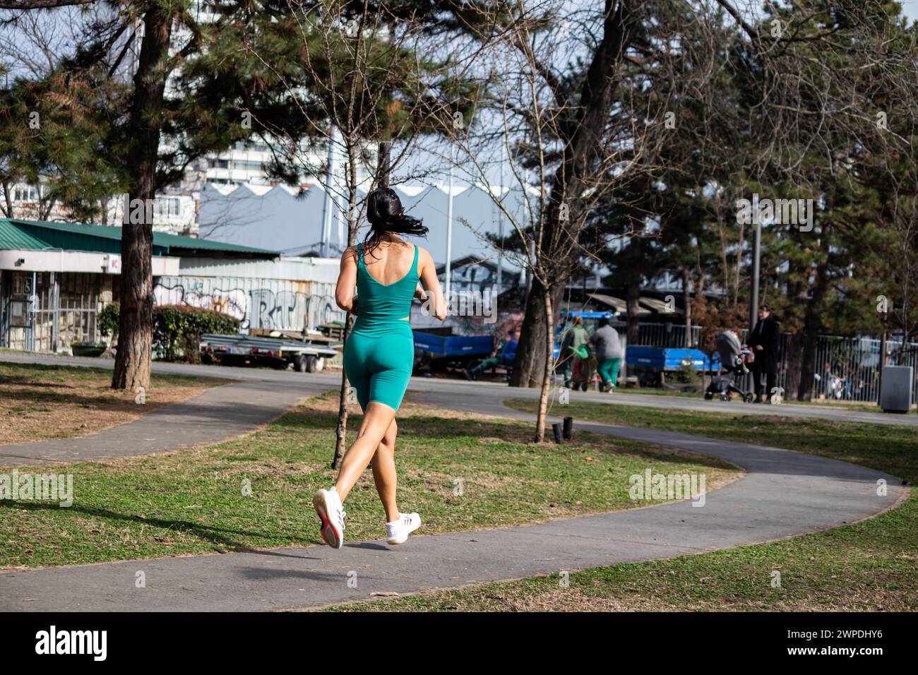 In forma bella ragazza che fa jogging nel parco verde al mattino, sana vita sportiva, rimanendo attivi Foto Stock