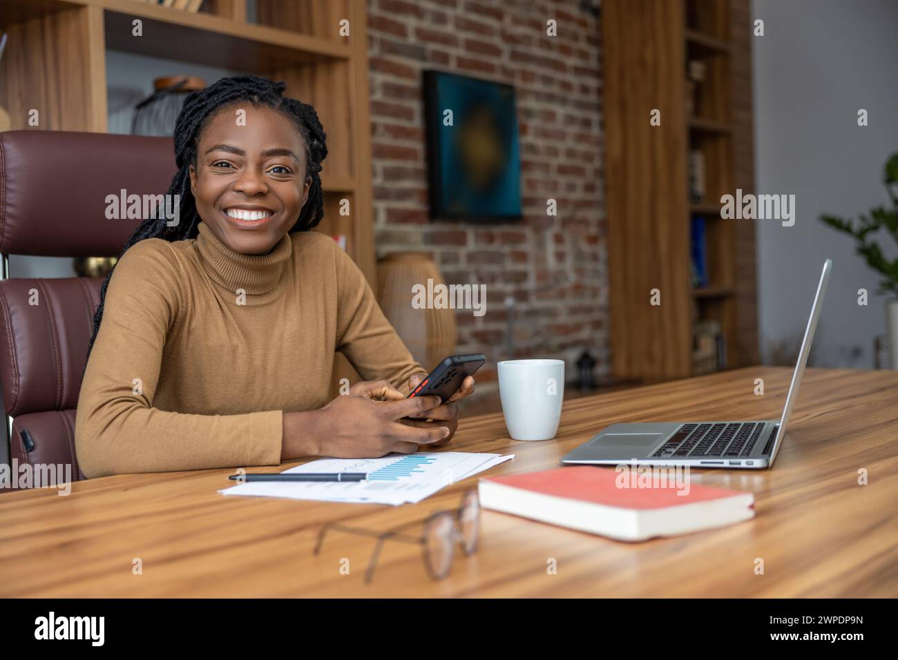 Donna con dreadlock lavora come freelance dall'ufficio domestico Foto Stock