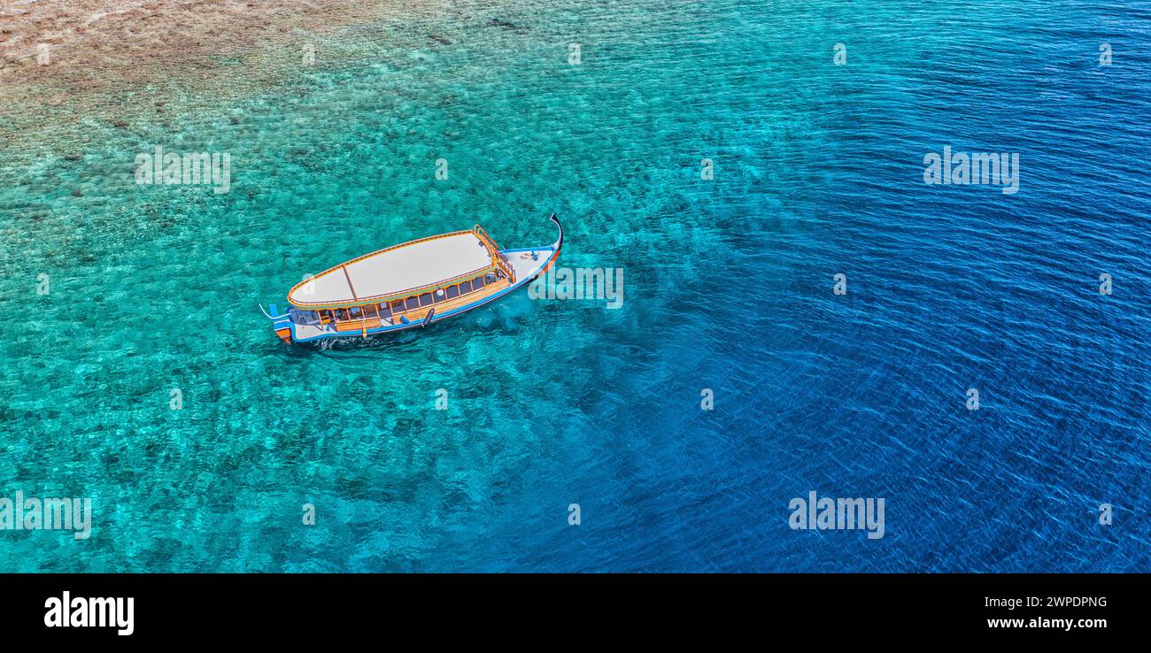Spiaggia e laguna cristallina con barca bianca. Vista dall'alto dello sfondo dell'acqua turchese. Il mare estivo dall'aria. Vista dall'alto dal drone. Vacanze estive Foto Stock