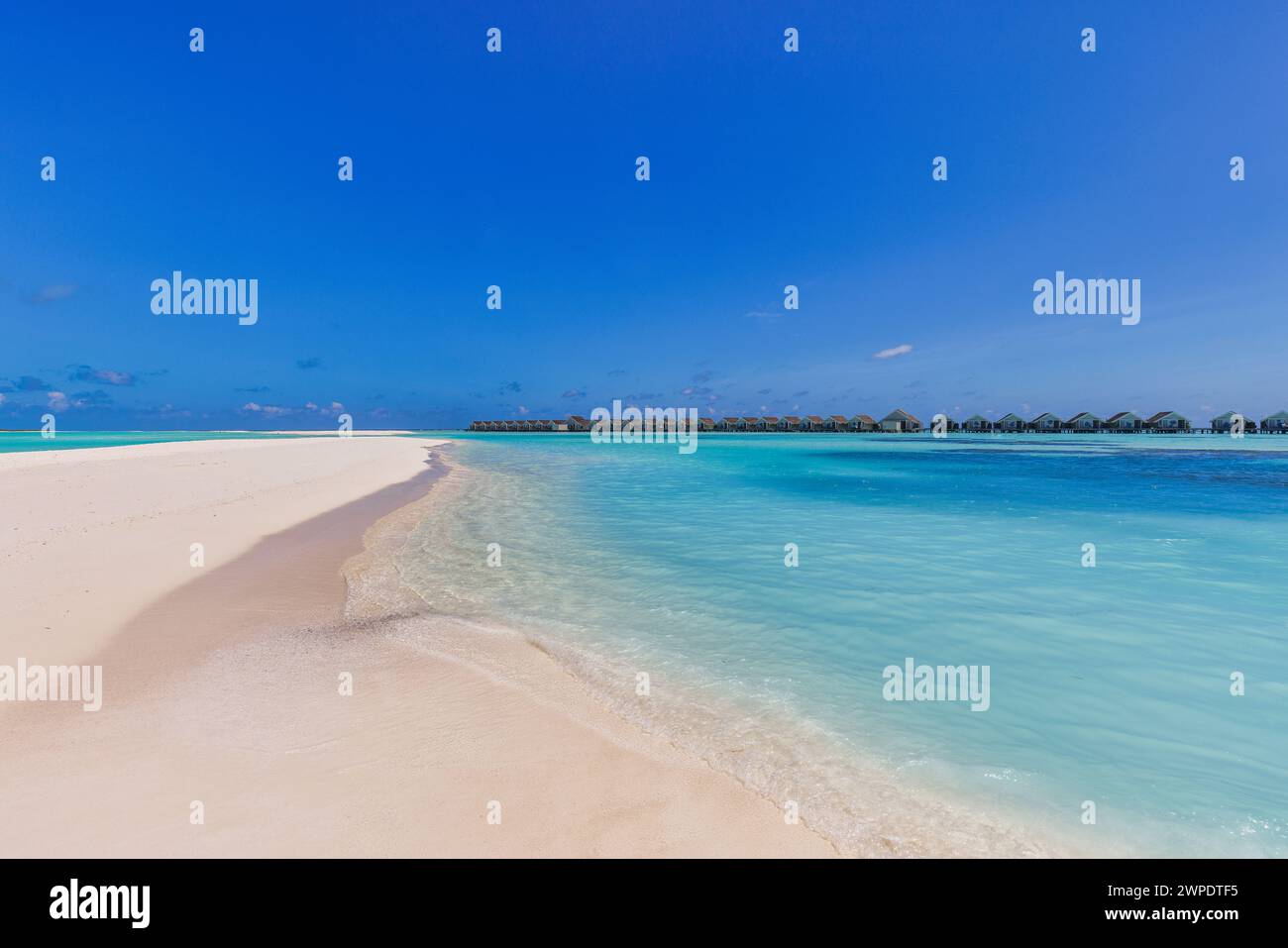 Paesaggio panoramico della spiaggia Maldive. Panorama tropicale, resort di lusso con ville d'acqua con molo o molo in legno. Sfondo di destinazione di viaggio di lusso Foto Stock