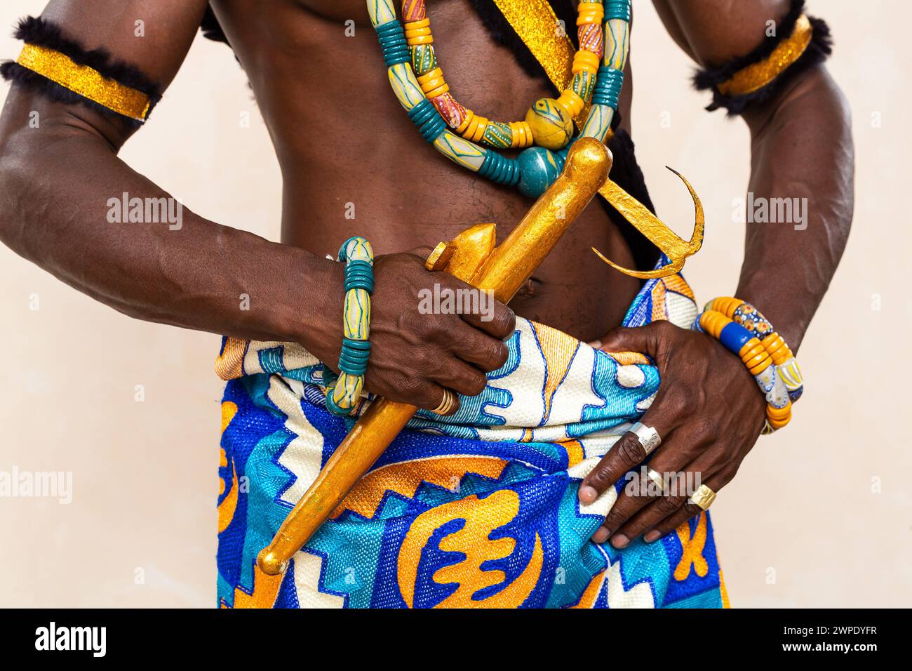 Vista ravvicinata dell'abbigliamento vivace e dei gioielli dettagliati di un uomo africano tradizionale, evidenziando i colori brillanti e gli intricati motivi simbolici del hi Foto Stock