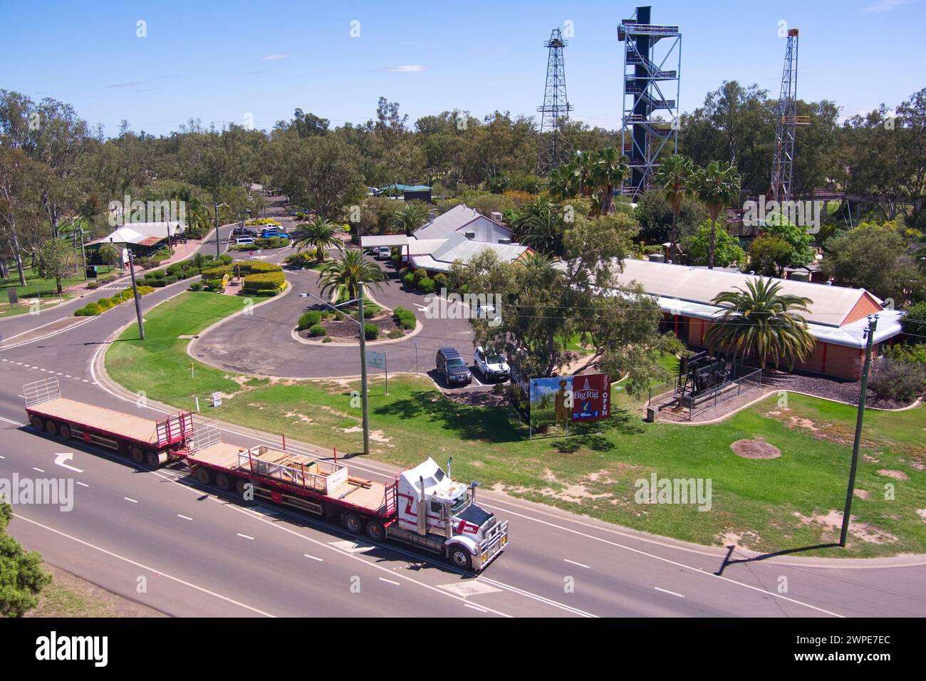 Treno stradale completamente carico che passa di fronte al complesso del Centro informazioni visitatori Big Rig a Roma Queensland Australia Foto Stock