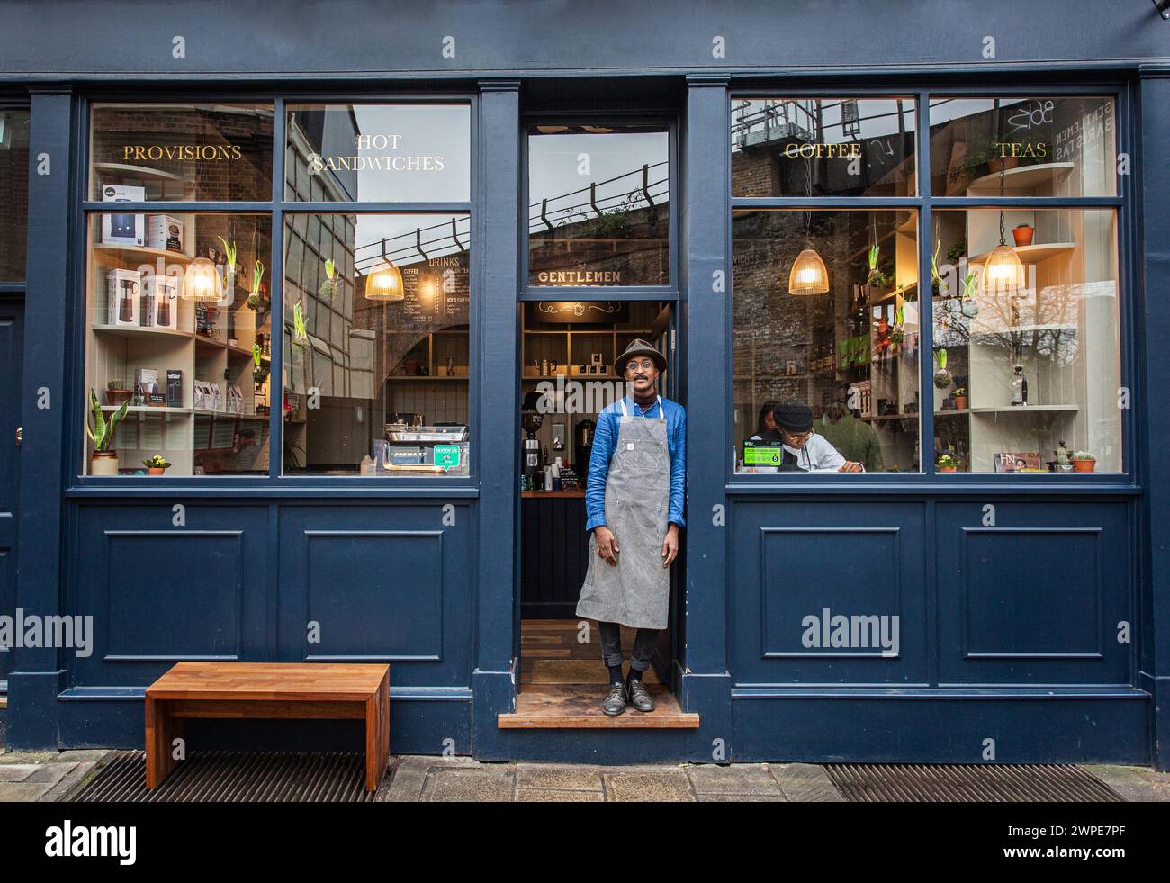 Caffè maschile Barista all'esterno della caffetteria, cibo e bevande di affari start up.Black barista maschile in piedi all'esterno della caffetteria Foto Stock