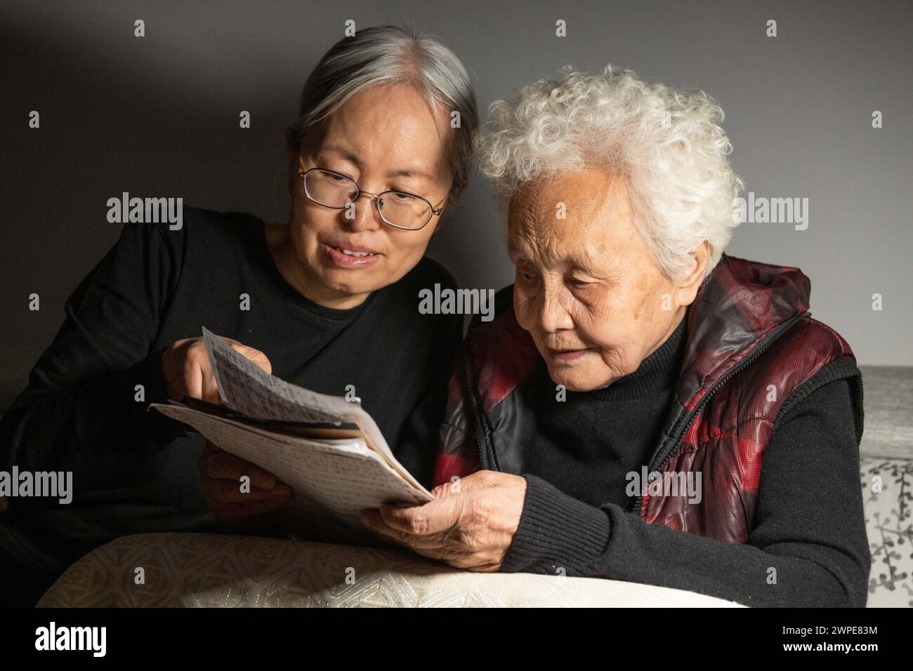 (240307) -- HARBIN, 7 marzo 2024 (Xinhua) -- Jiang Shumei (R) controlla una bozza con sua figlia Zhang che sta male a casa nel distretto di Beilin della città di Suihua, nella provincia di Heilongjiang della Cina nord-orientale, 5 marzo 2024. Jiang Shumei, 87 anni, una nonna analfabeta che ha imparato a leggere all'età di 60 anni, ha dipinto più di 300 dipinti e pubblicato 6 libri, realizzando una straordinaria trasformazione nei suoi anni crepuscolari. Nato nella contea di Juye della provincia cinese di Shandong nel 1937, Jiang vive attualmente nella città di Suihua, nella provincia cinese di Heilongjiang. Nel 1996, il marito di Jiang è morto in un incidente stradale. Per tornare Foto Stock