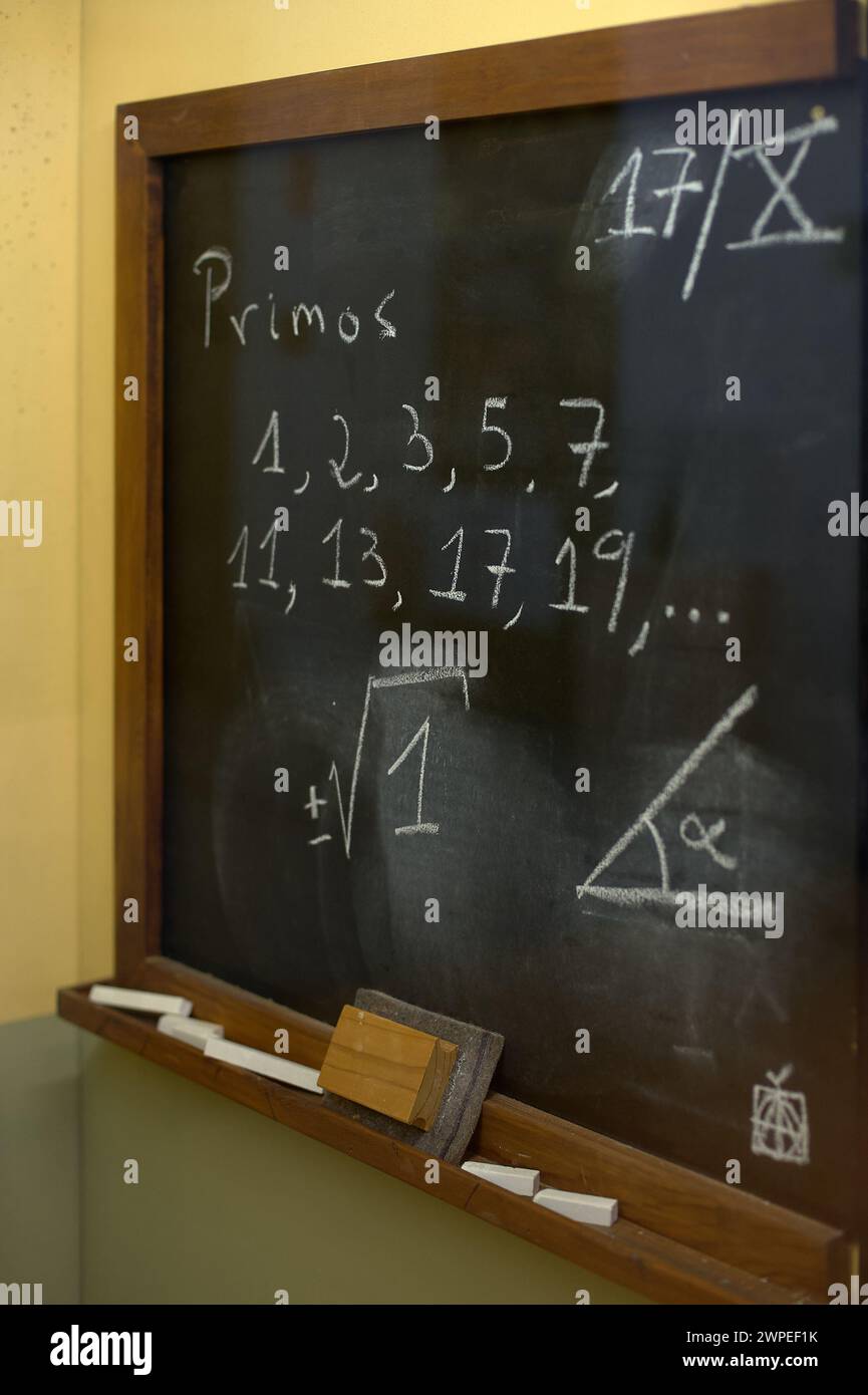 Lavagna in classe che mostra un elenco di numeri primi e disegni geometrici, ideale per contesti educativi. Foto Stock