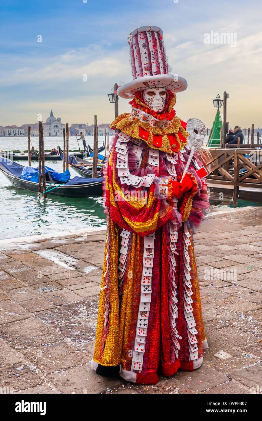 Una persona vestita per il carnevale di fronte alle gondole e alla laguna veneta in Veneto Foto Stock