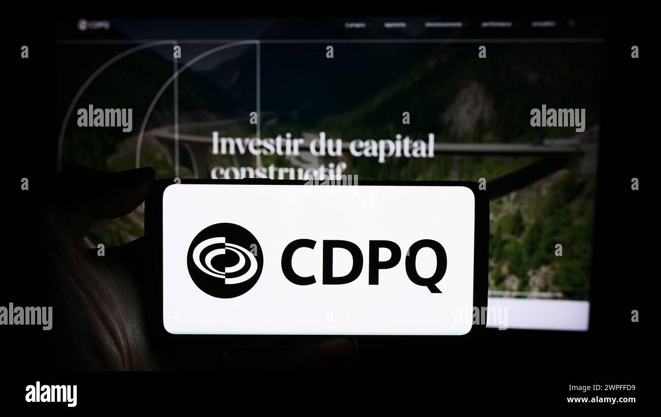 Persona che detiene un cellulare con il logo della Caisse de Depot et Placement du Quebec (CDPQ) di fronte alla pagina web aziendale. Mettere a fuoco il display del telefono. Foto Stock