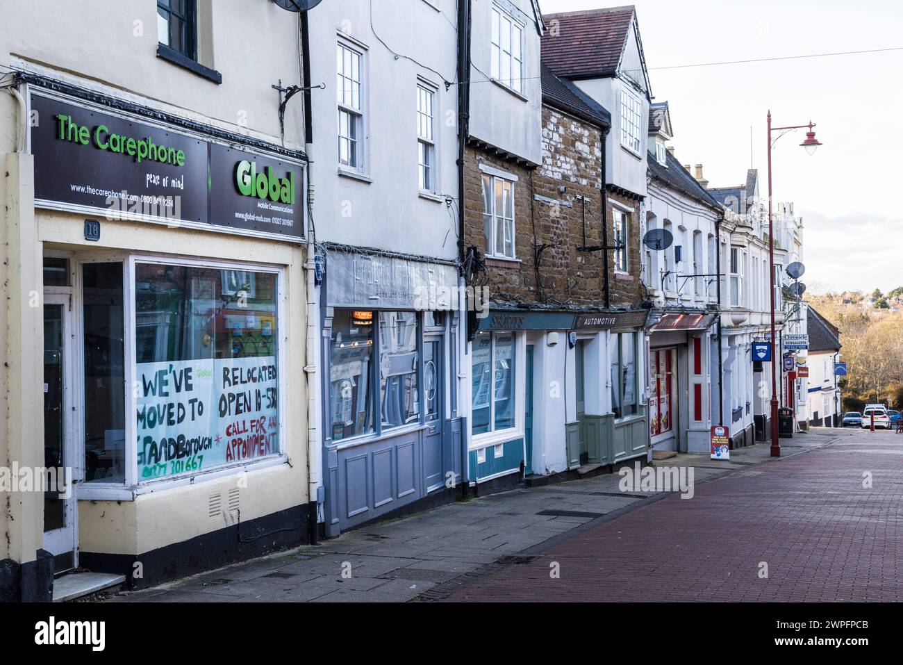 Fila di negozi con uno chiuso per il trasferimento, Daventry, Inghilterra, Regno Unito Foto Stock