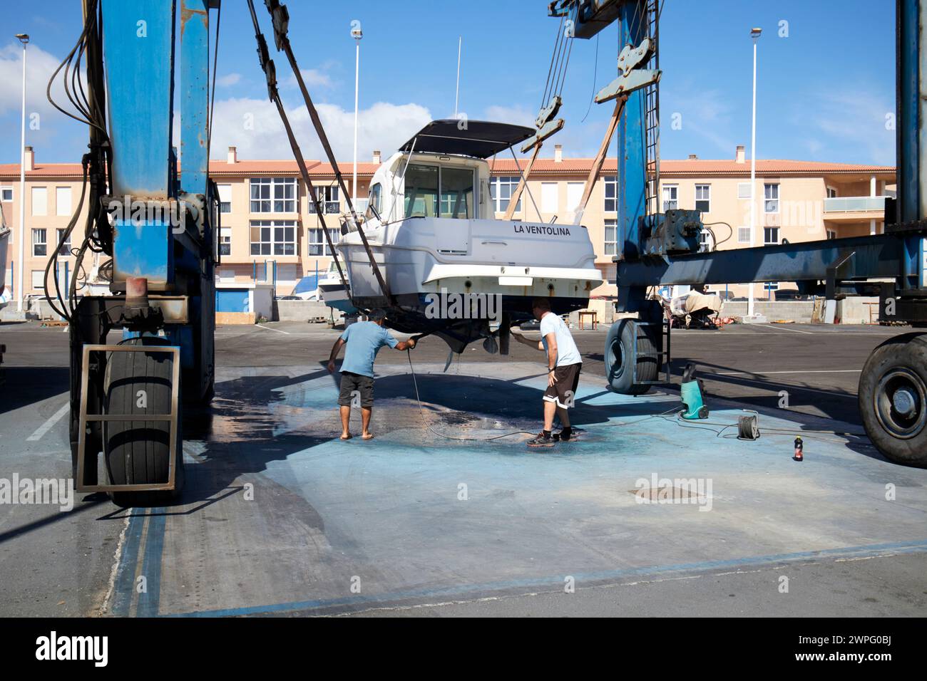 Pulizia della parte inferiore di una barca su un ascensore nel porto turistico di Corralejo, fuerteventura, Isole Canarie, spagna Foto Stock