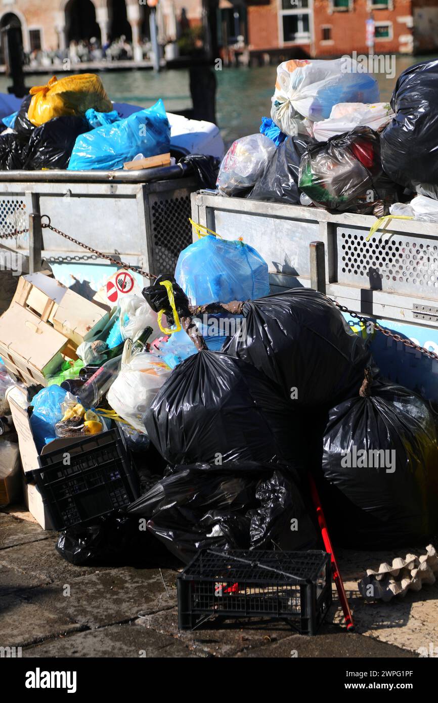 Diversi sacchetti per rifiuti in un cassonetto sovraccarico in città Foto Stock