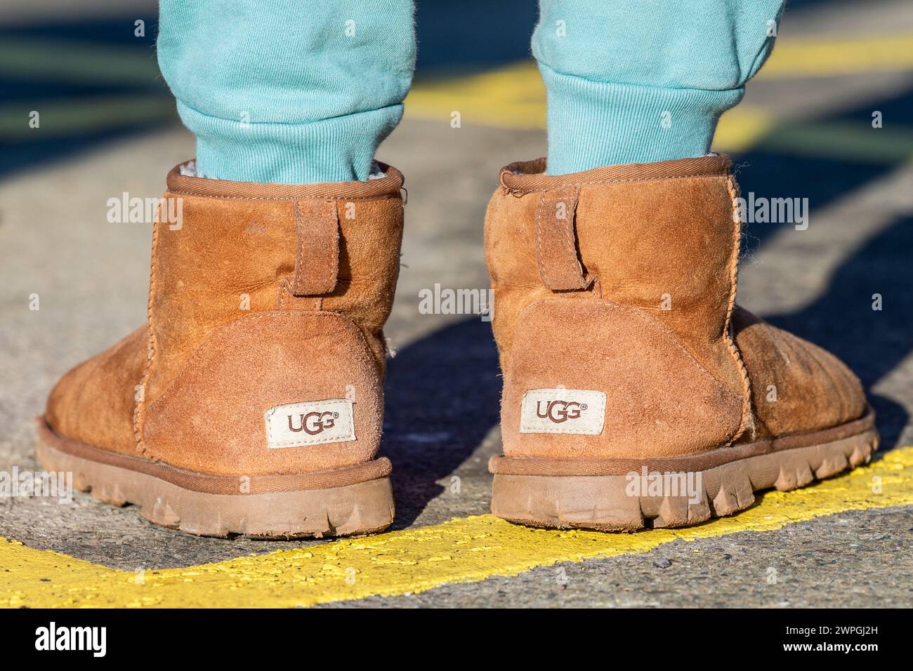 Giovane ragazza che indossa un paio di stivali UGG contraffatti o falsi. Foto Stock