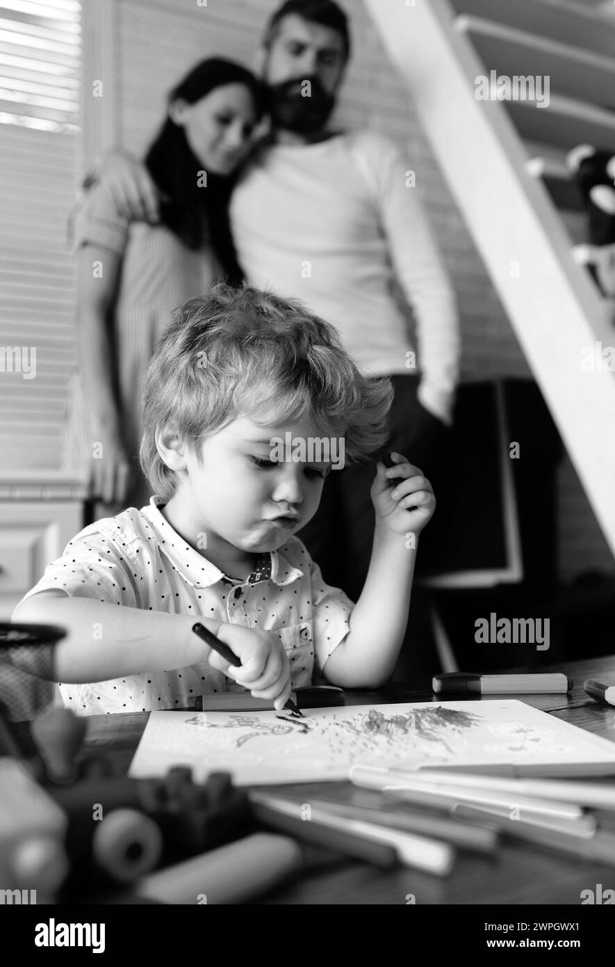 Mamma e papà che disegnano con il bambino. Famiglia felice di tre divertirsi insieme. Genitori allegri che giocano con figlio. Padre madre e bambino che giocano insieme Foto Stock