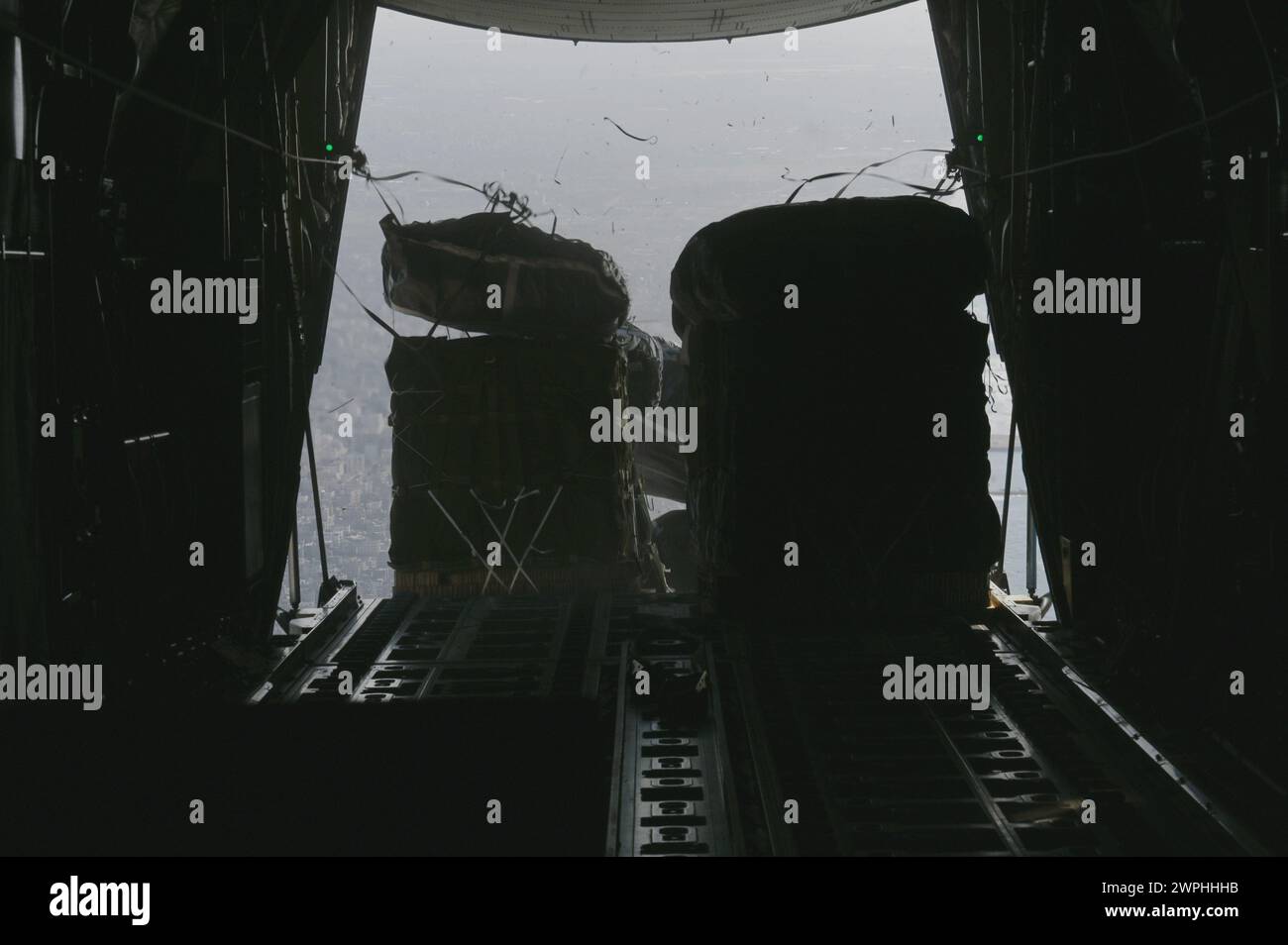 Un C-130J Super Hercules della U.S. Air Force conduce un airdrop di assistenza umanitaria su Gaza, 7 marzo 2024. Gli aiuti umanitari comprendono oltre 66 pacchetti di cibo, che forniscono oltre 38.000 pasti ai civili più bisognosi di assistenza a causa del conflitto in corso nella regione. Il comando centrale degli Stati Uniti e gli Stati Uniti sono impegnati a sostenere la missione umanitaria per gli aiuti alla popolazione di Gaza. (Foto di cortesia dell'aeronautica militare statunitense) Foto Stock