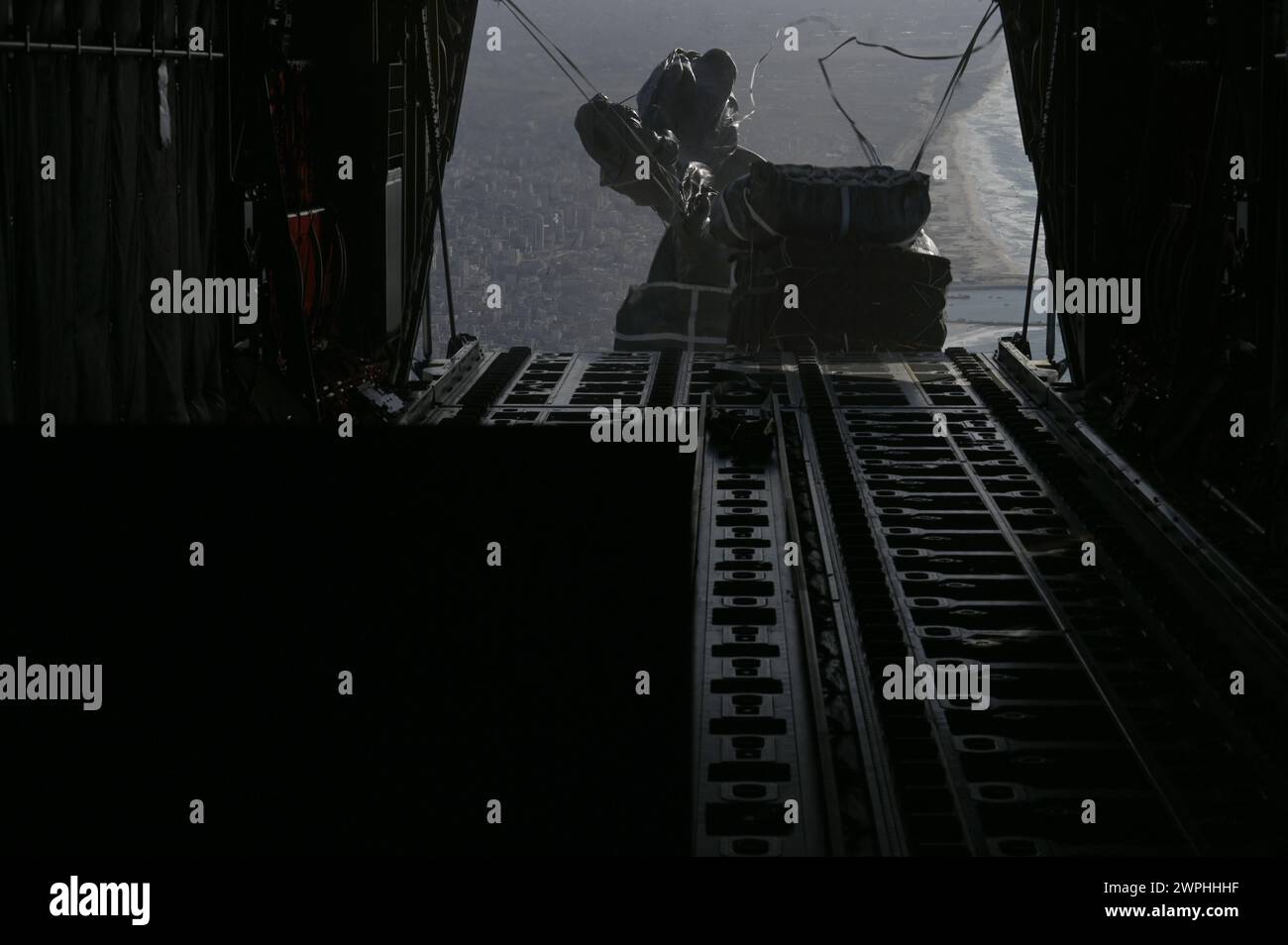 Un C-130J Super Hercules della U.S. Air Force conduce un airdrop di assistenza umanitaria su Gaza, 7 marzo 2024. Gli aiuti umanitari comprendono oltre 66 pacchetti di cibo, che forniscono oltre 38.000 pasti ai civili più bisognosi di assistenza a causa del conflitto in corso nella regione. Il comando centrale degli Stati Uniti e gli Stati Uniti sono impegnati a sostenere la missione umanitaria per gli aiuti alla popolazione di Gaza. (Foto di cortesia dell'aeronautica militare statunitense) Foto Stock