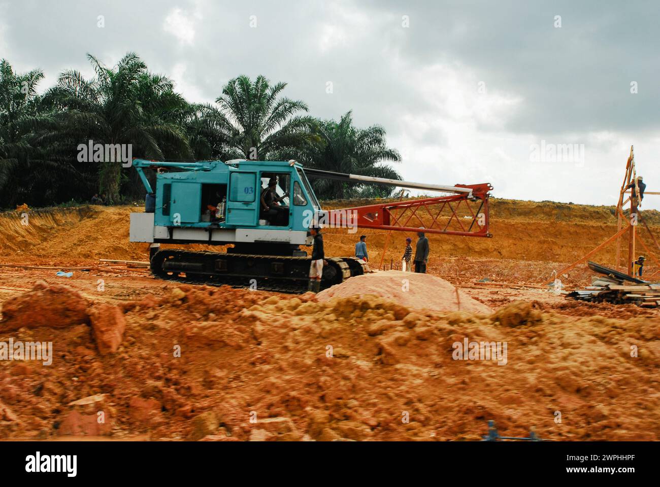 lavoratori e bulldozer nelle piantagioni di olio di palma Foto Stock