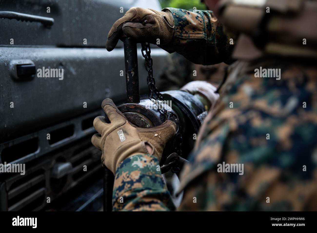 Un Marine degli Stati Uniti con Combat Logistics Battalion 4, Combat Logistics Regiment 3, 3rd Marine Logistics Group, collega un meccanismo di aggancio da un relitto AMK36 durante uno scambio bilaterale di operazioni di recupero presso l'Eastern Training area, Camp Hansen, Okinawa, Giappone, 5 febbraio, 2024. lo scambio bilaterale delle operazioni di recupero è stato tra i membri del servizio della forza di autodifesa terrestre giapponese con la 15th Logistics Support Unit, la 15th Brigade, l'esercito occidentale e i Marines statunitensi con CLB-4; e faceva parte di un'esercitazione sul campo di battaglione che ha provato operazioni logistiche cruciali eseguite all'interno di un Alert Contingency Mar Foto Stock