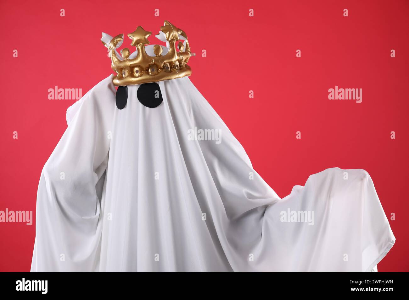 Persona in costume fantasma e lussuosa corona su sfondo rosso Foto Stock