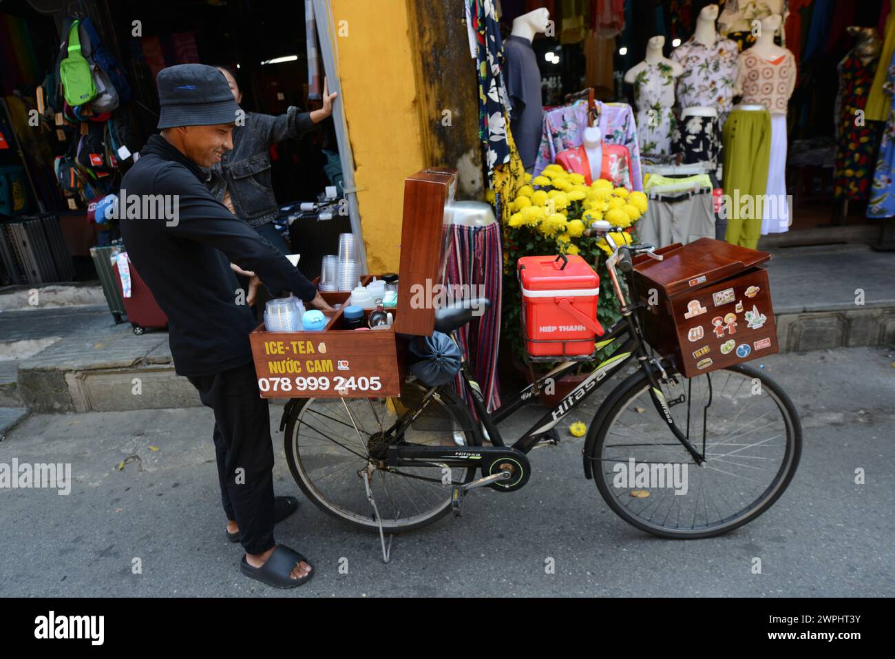 Un uomo che vende bevande dal suo banco di biciclette mobili. Città vecchia di Hoi An, Vietnam. Foto Stock