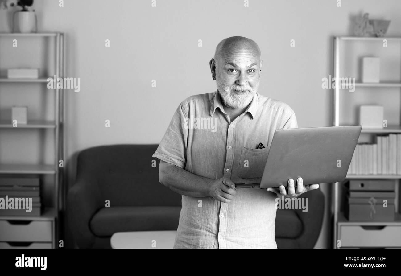 Ritratto di uomo anziano dai capelli grigi che lavora in ufficio o a casa. Comunicazione online, videoconferenza. Riunione online, videochiamata, lavoro remoto Foto Stock