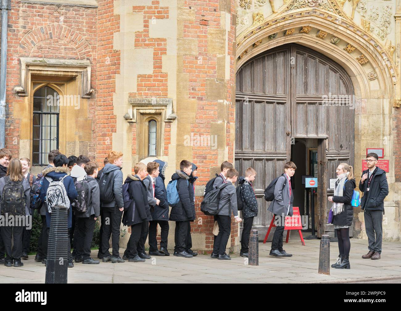 Un gruppo di scolari si schiera fuori dal St John's College, Università di Cambridge, Inghilterra, prima dell'ingresso. Foto Stock