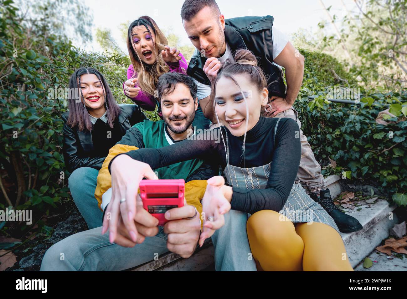 Giovani adulti impegnati nel gioco portatile - attività di svago gioiose in un ambiente naturale - che condividono l'emozione di un gioco classico Foto Stock