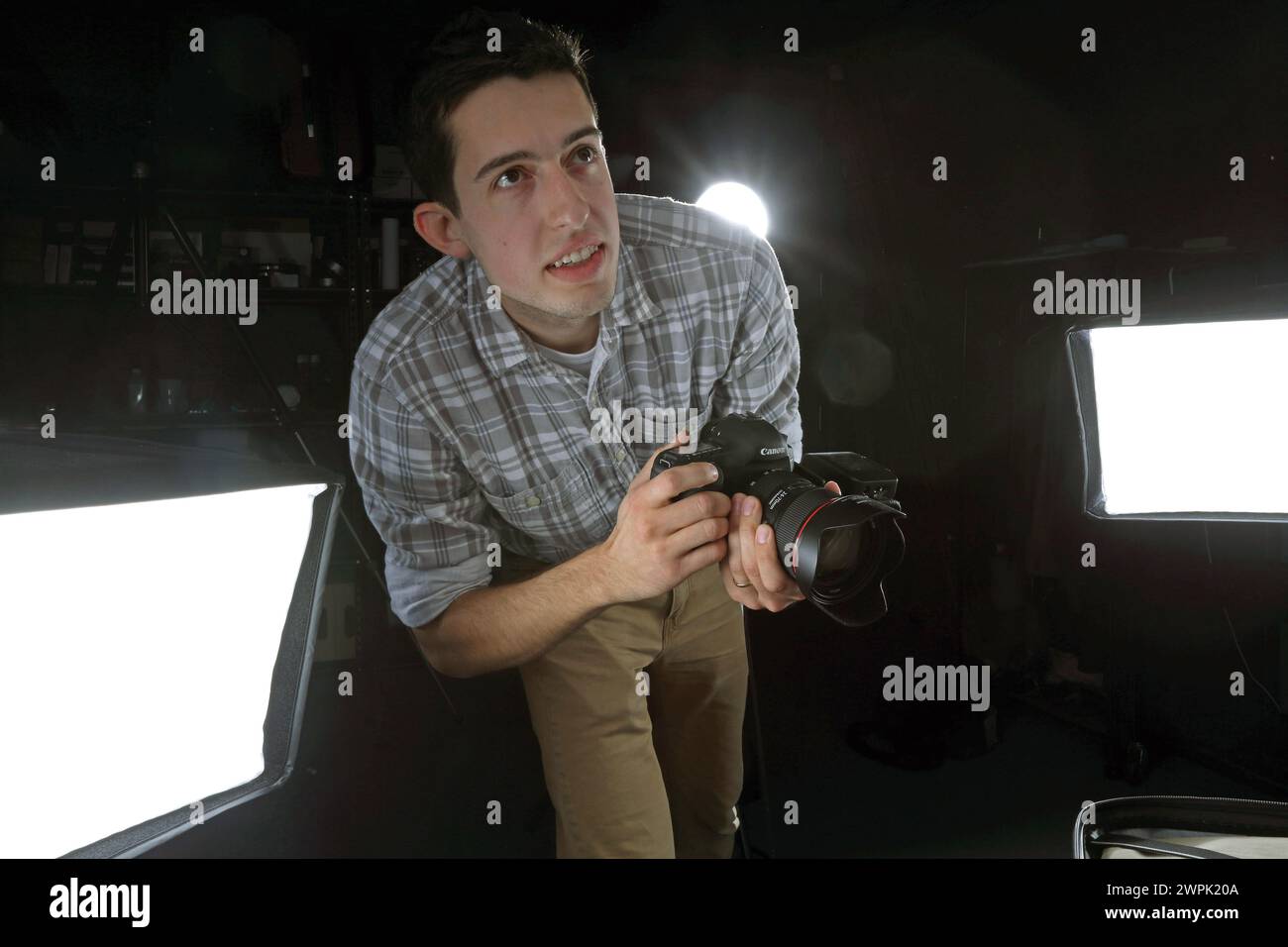 Fotografo in studio con apparecchiature di illuminazione Foto Stock