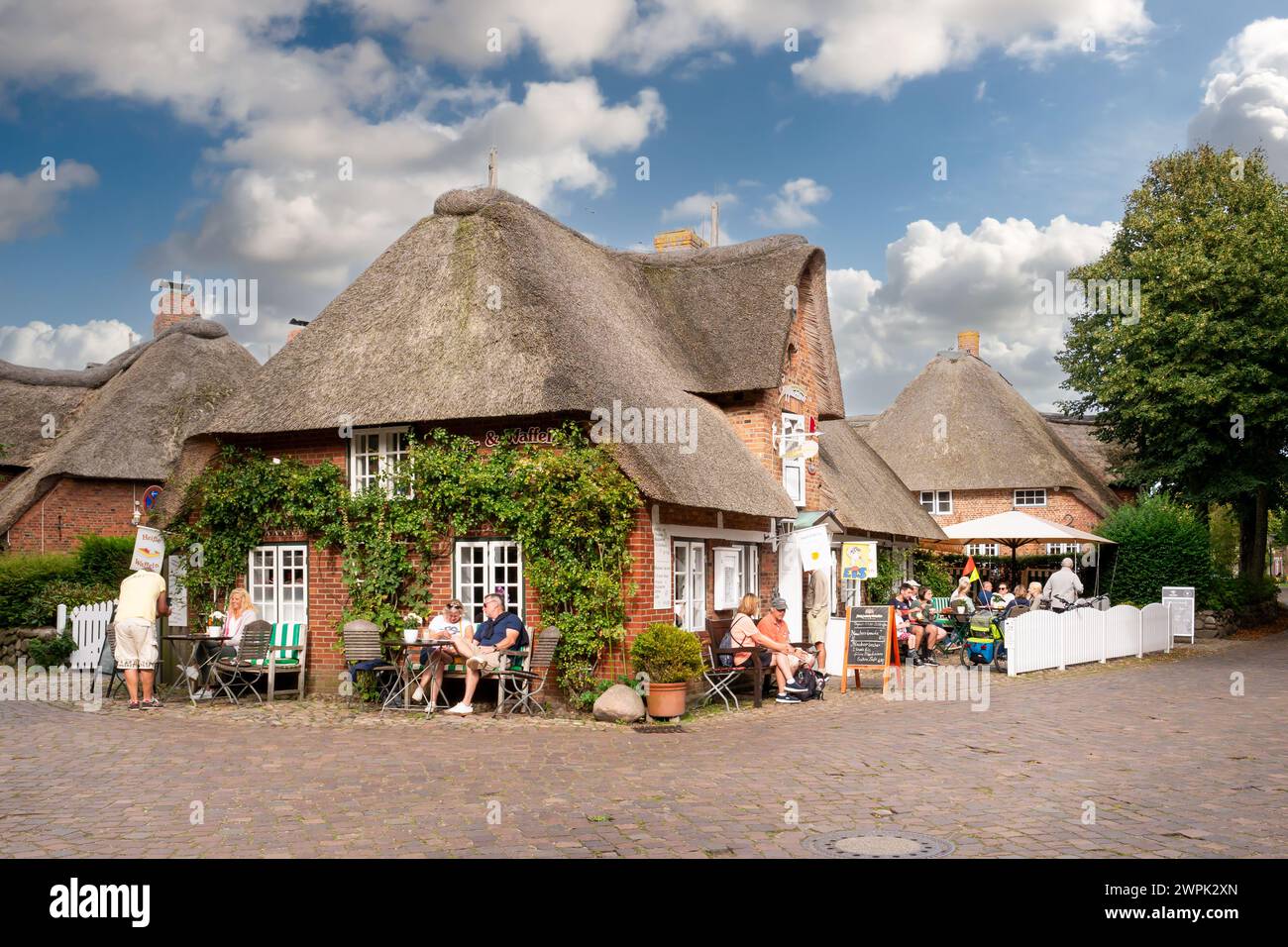 Persone che si rilassano sulla terrazza esterna del caffè a Nieblum sull'isola di Foehr, Frisia settentrionale, Schleswig-Holstein, Germania Foto Stock