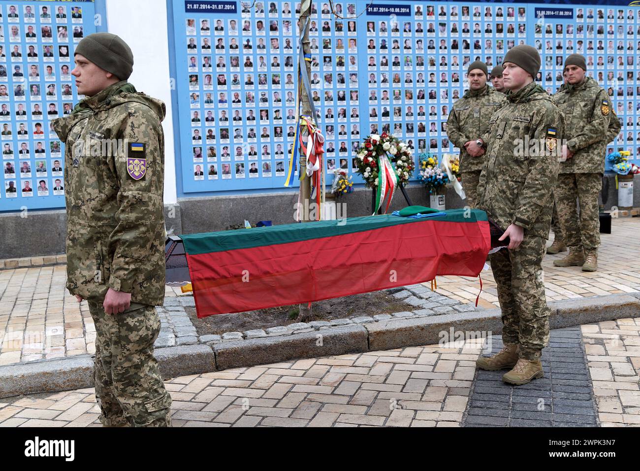 KIEV, UCRAINA - 7 MARZO 2024 - i servitori tengono il coperchio della bara del volontario lituano Tadas Tumas, ucciso in prima linea vicino a Bakhmut, regione di Donetsk, il 23 febbraio 2024, coperto di bandiera lituana dopo il servizio commemorativo nella cattedrale di San Michele con la cupola dorata, Kiev, capitale dell'Ucraina. Foto Stock